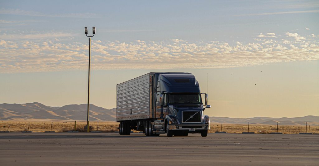 freightliner semi truck at sunset in a parking lot