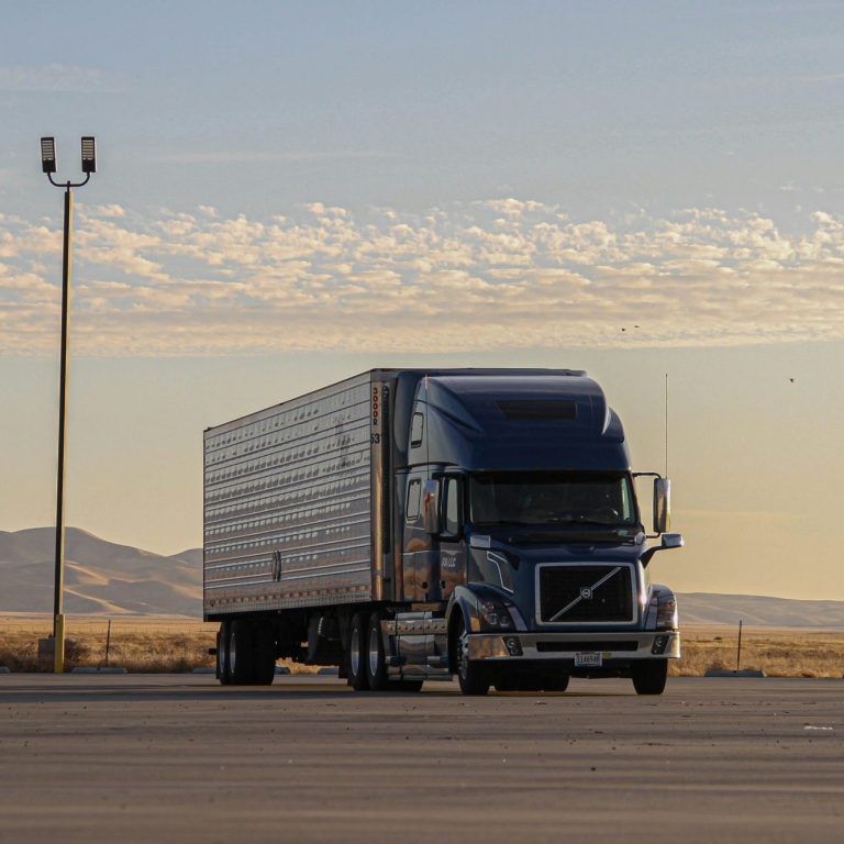 freightliner semi truck at sunset in a parking lot